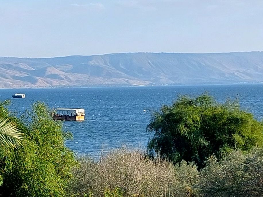 View of the Sea of Galilee with boats on the water and hills in the background