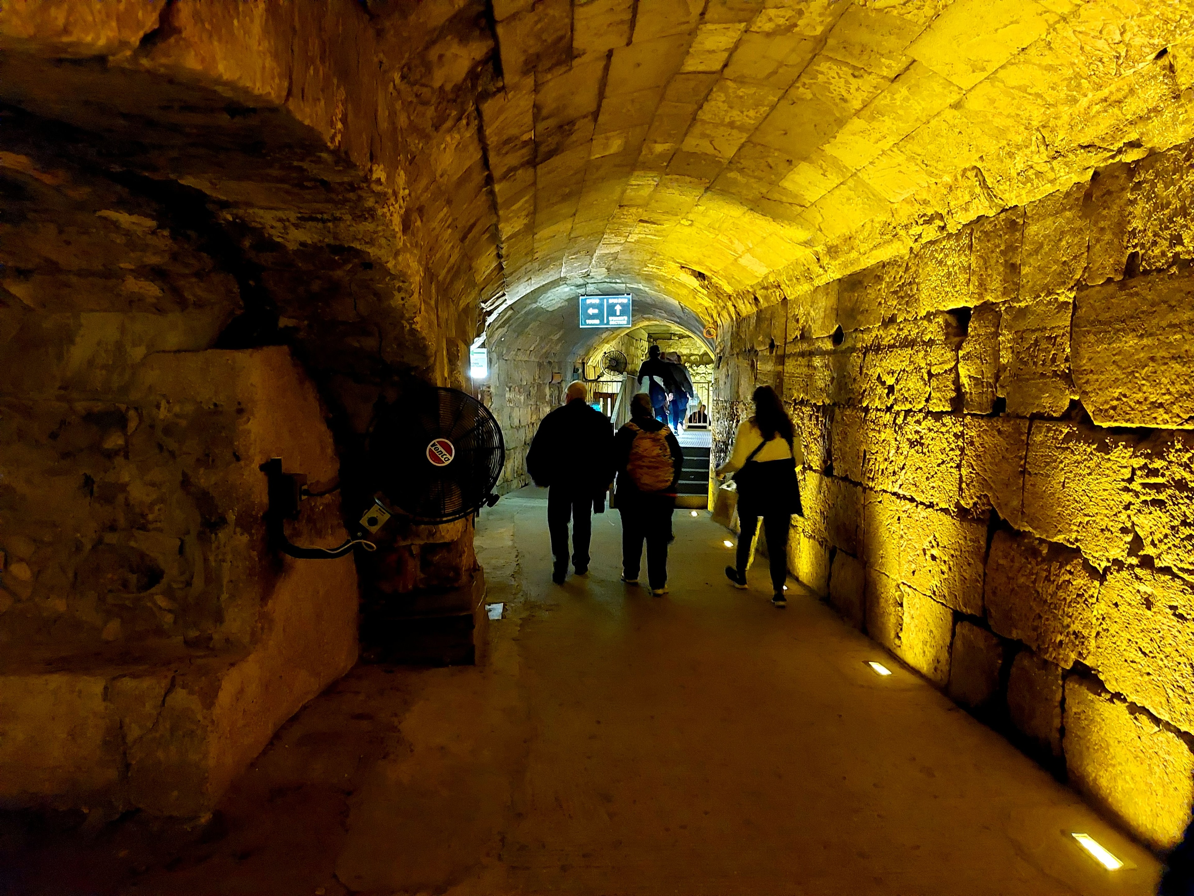 An ancient tunnel under the Temple Mount in Jerusalem, lit with warm golden light