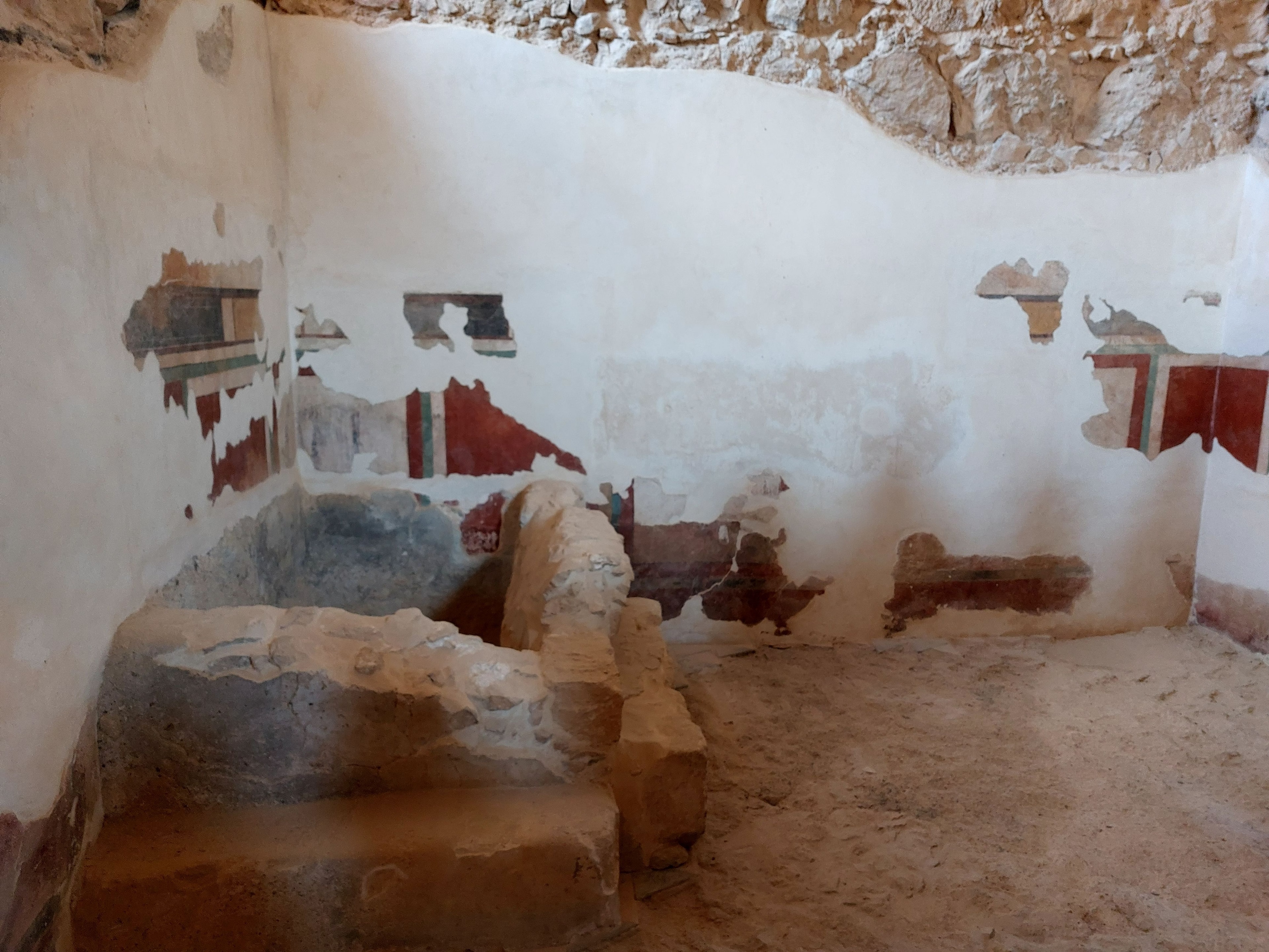 Herodian-era bathtub with colorful fresco plaster still on the walls at Masada