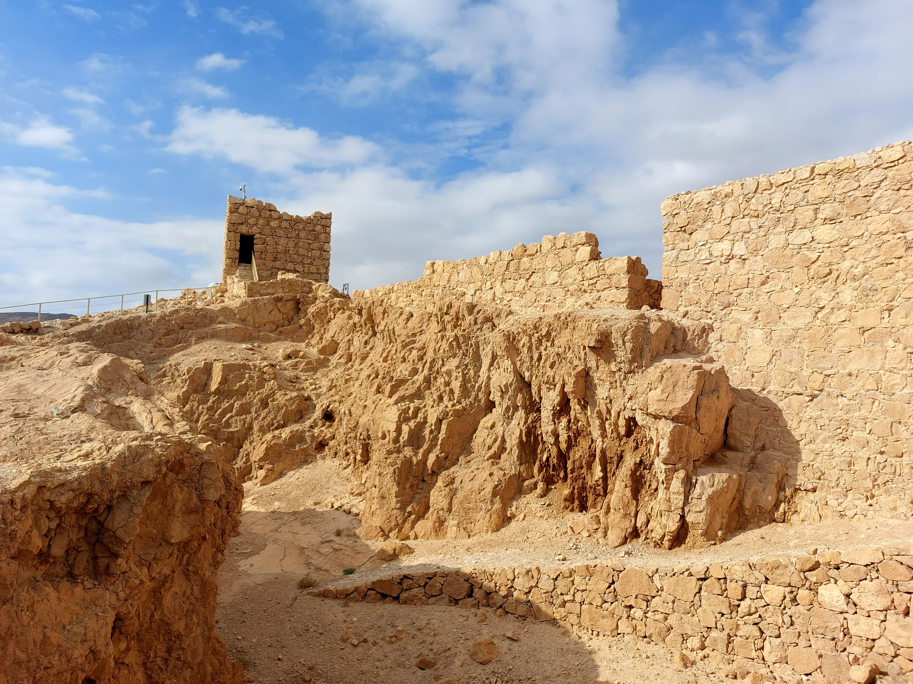 The Herodian fortifications on the mountain at Masada with stone walls and watchtower