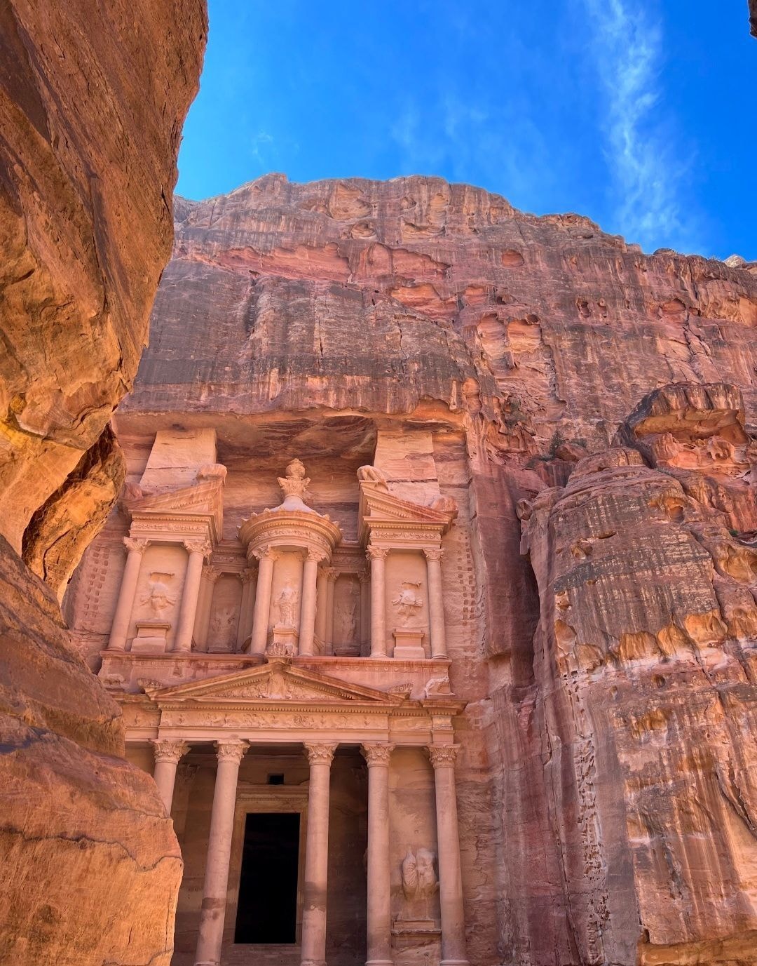 Close-up view of Petra's Treasury facade carved into rose-red sandstone cliffs in Jordan