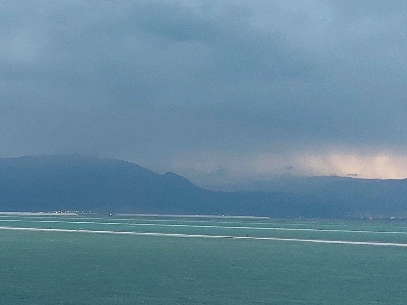 Rain falling on the Dead Sea with mountains in the background
