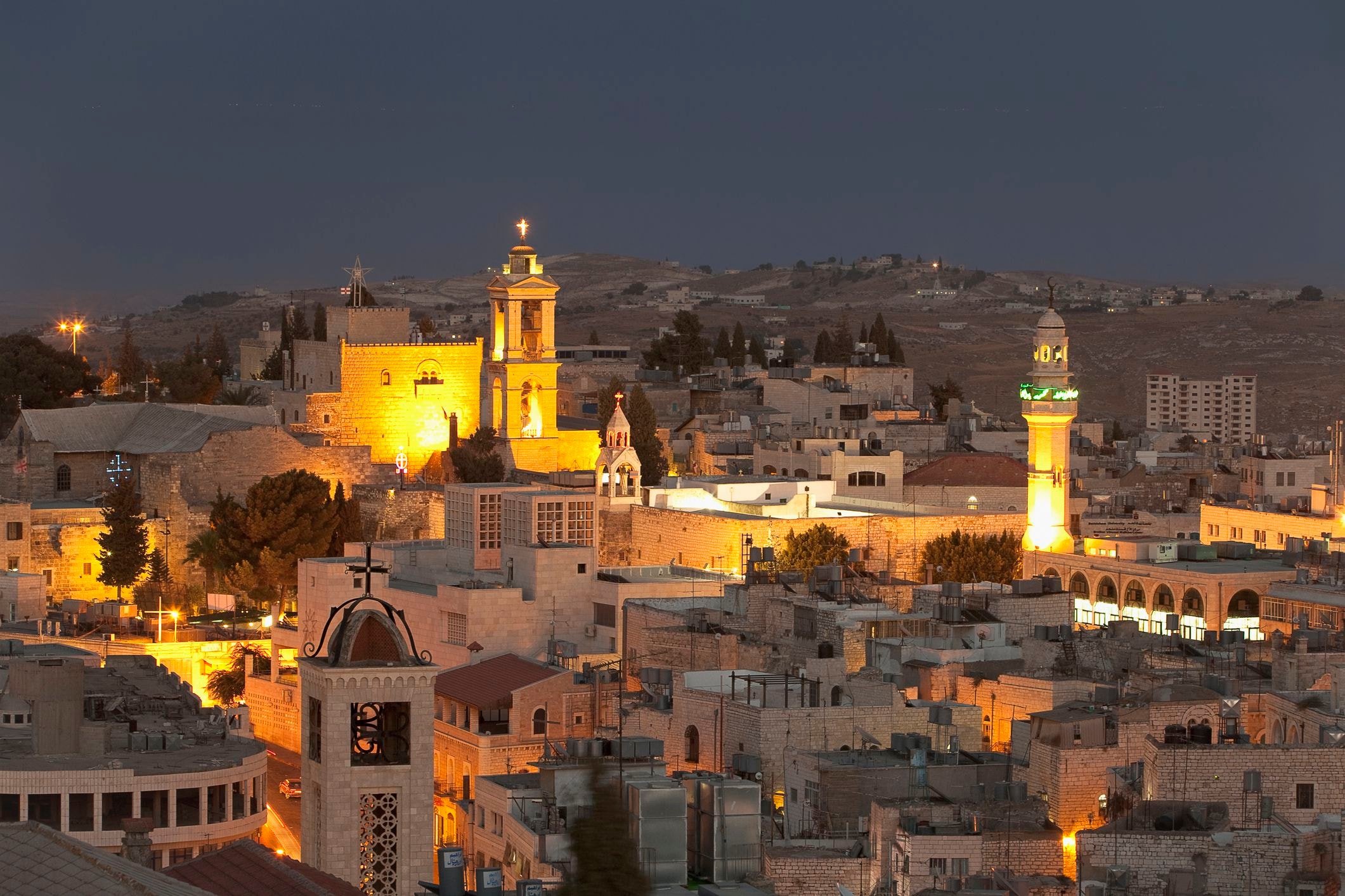 Bethlehem at night with illuminated churches and ancient architecture