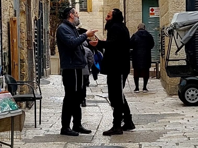 Two men having a spirited discussion in old Jerusalem